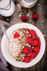 Healthy breakfast: oatmeal with fresh raspberries, flax seeds and pumpkin seeds