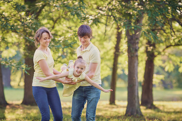 Fototapeta premium Happy family in the park on a tree background.