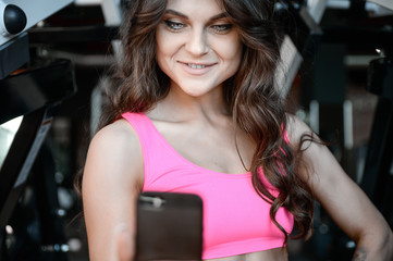 Fototapeta na wymiar Fitness girl with a beautiful smile posing and exercise in the gym.