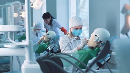 Students practicing dentistry on medical dummies in a teaching facility or university - obrazy, fototapety, plakaty