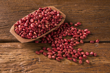 Raw peanuts in wood bowl.