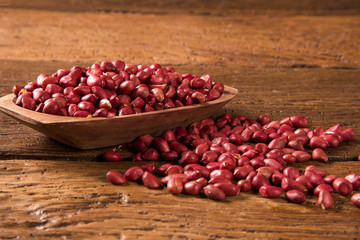 Raw peanuts in wood bowl.