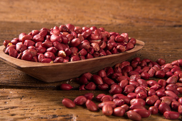 Raw peanuts in wood bowl.
