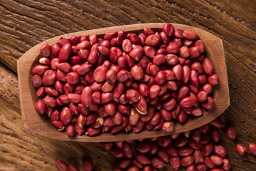 Raw peanuts in wood bowl.