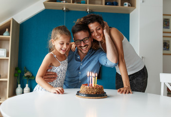 Father's birthday.Wife surprise her husband with birthday cake .