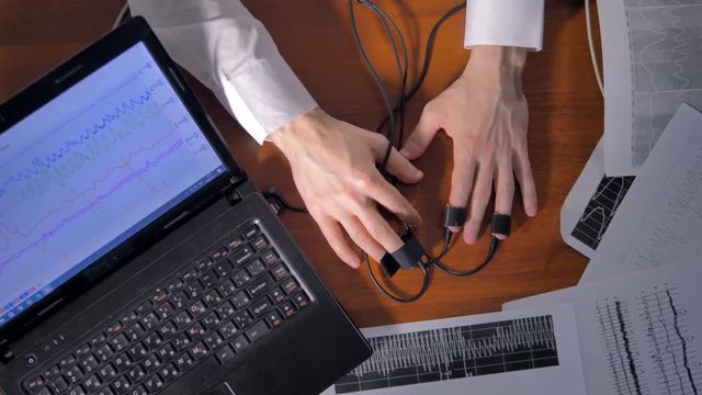 Stressed man's hands during polygraph test. 4K.