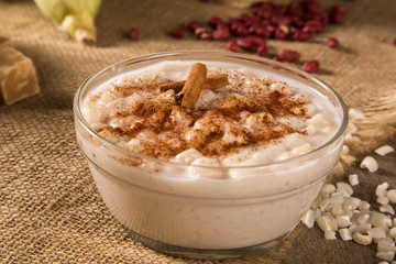 Brazilian dessert canjica of white corn with cinnamon in transparent plate.