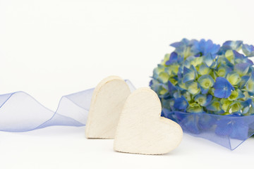 blue flower and wooden heart lying on white