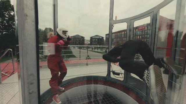 Two skydivers train in wind tunnel. Skydiver flies in wind tube. Sky diving