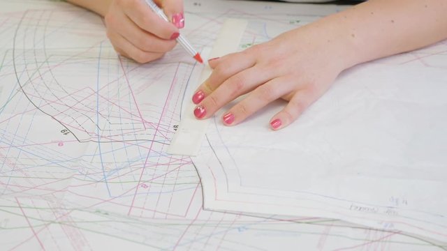 Sewing dressmaking patterns design. Fashion Design Studio. Pattern Making. Designer makes an adjustments in the drawing.