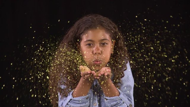 Cute little girl blowing glitter.
