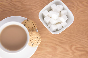 English tea with biscuits and sugar cubes in a bowl