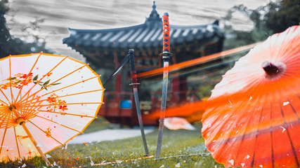 Two katana sword around umbrellas against the backdrop of the Japanese gazebo. Format 16:9 (film frame).