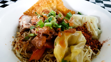 Spicy curry instant noodles soup with fork on wooden dining table