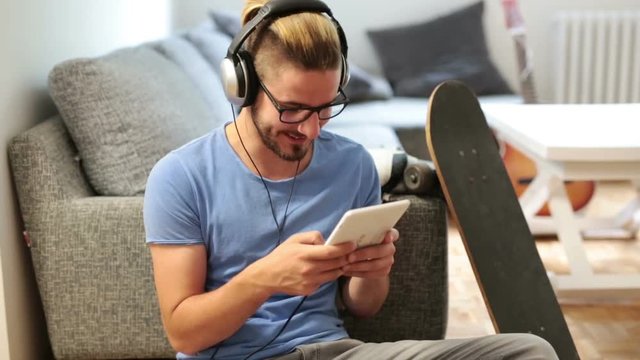 Man listening music on tablet at his home