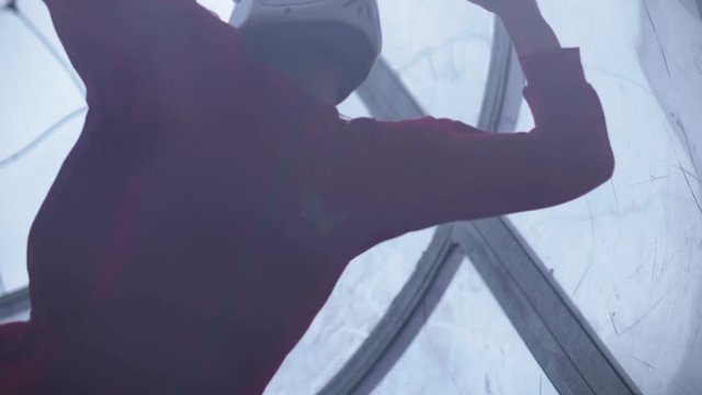 Close up girl skydiver flies in air into wind tunnel. Flying in a wind tunnel