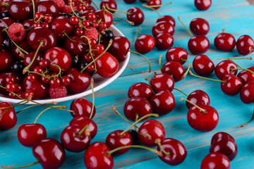 Mature berries on a plate on a wooden table