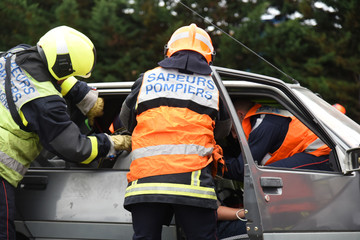 pompiers secourant des victimes d'un accident de voiture