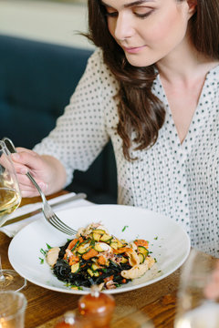 Young woman looking down at her plate with fancy fod