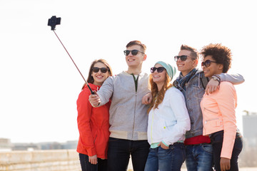 happy friends taking selfie by smartphone outdoors