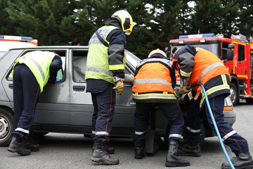 pompiers secourant des victimes d'un accident de voiture