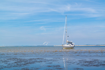 Sailboat aground on sandflat at low tide near Rotterdam, Netherlands