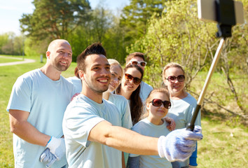 group of volunteers taking smartphone selfie