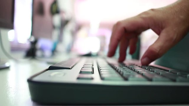 hands man typing on laptop computer keyboard in blur library Conner background