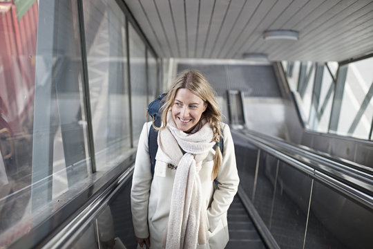 Smiling woman standing on escalators