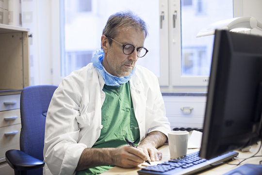 Surgeon doctor writing by desk