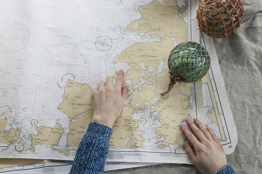 Hand over seachart by floating glassballs