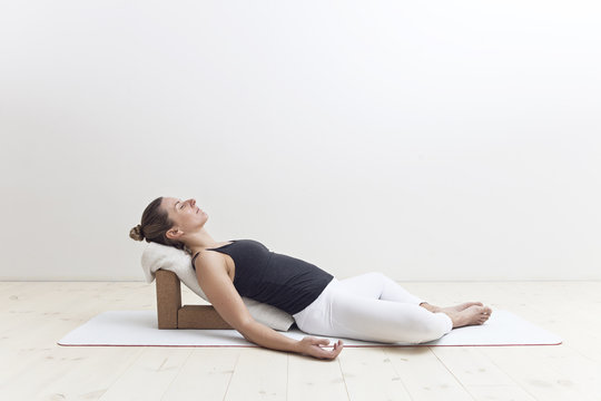 Woman practicing restorative yoga in studio