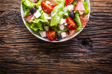 Salad. Fresh summer lettuce salad.Healthy mediterranean salad olives tomatoes parmesan cheese and prosciutto.