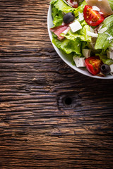 Salad. Fresh summer lettuce salad.Healthy mediterranean salad olives tomatoes parmesan cheese and prosciutto.