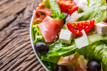 Salad. Fresh summer lettuce salad.Healthy mediterranean salad olives tomatoes parmesan cheese and prosciutto.