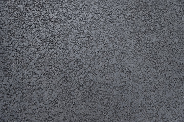 Dark grey asphalt background texture close up