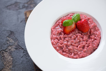 Closeup of a white plate with strawberry risotto, selective focus, studio shot