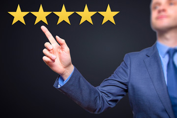 Review, increase rating or ranking, evaluation and classification concept. Businessman pointing on five yellow stars to increase rating of his company.