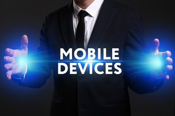 Business, Technology, Internet and network concept. Young businessman working on a virtual screen of the future and sees the inscription: Mobile devices
