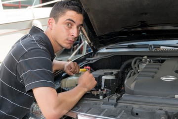 Fototapeta na wymiar young man mechanic repairing motor of car