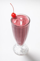 Strawberry Shake decorated with cherry on a white background