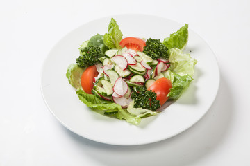 Salad with tomatoes and cucumbers, radishes on the plate