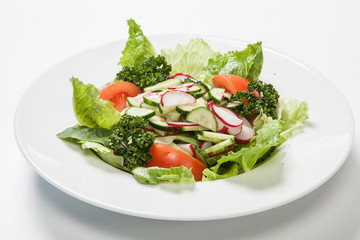 Salad with tomatoes and cucumbers, radishes on the plate