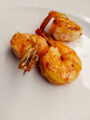 Grilled shrimps with spice and lemon in a white dish. Grilled seafood.
