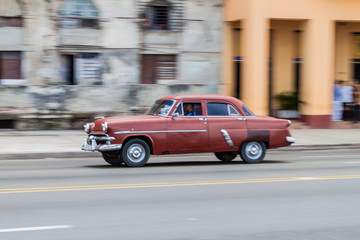 HAVANA, CUBA - FEB 22, 2016: Vintage car rides along the famous seaside drive Malecon in Havana