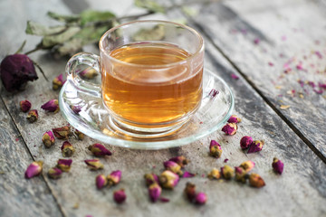 tea made from tea rose petals in a glass bowl on wooden  background