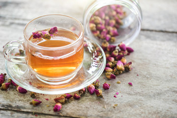 tea made from tea rose petals in a glass bowl on wooden  background