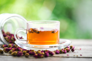 tea made from tea rose petals in a glass bowl on wooden  background