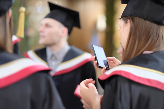 Graduates of the university in the traditional academic mantle with telephones