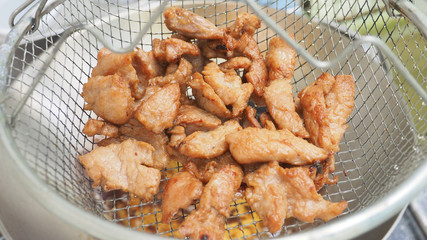 Fried pork in grid basket hanging to drying and zoom in